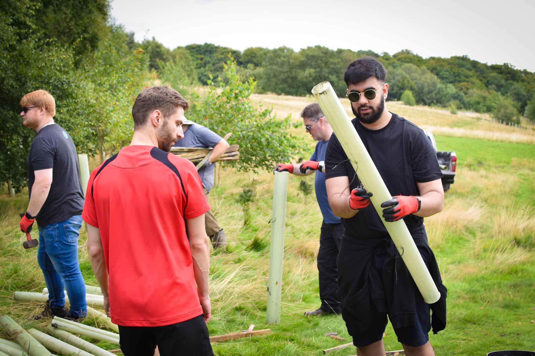 Tom and Muhammad planting a tree.